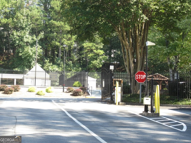 4018 Woodridge Way, Tucker, GA 30084 - view of road featuring traffic signs, street lights, and a gate