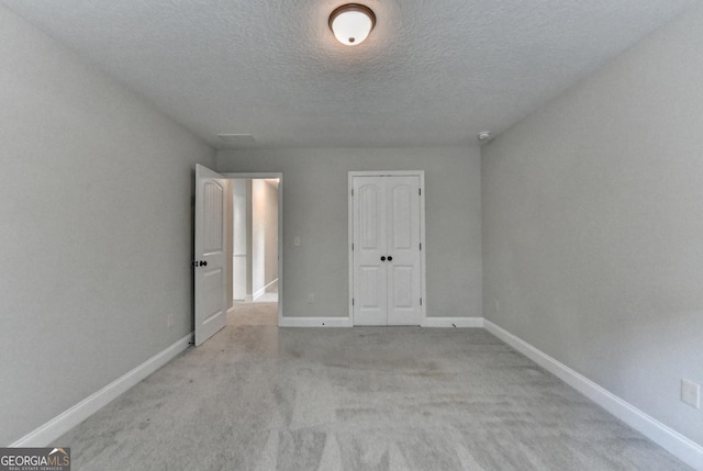 unfurnished room with baseboards, carpet floors, and a textured ceiling