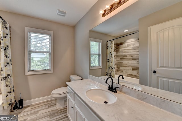 bathroom featuring toilet, a shower with curtain, vanity, visible vents, and baseboards