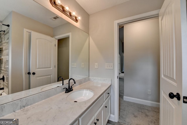 bathroom featuring walk in shower, visible vents, baseboards, and vanity