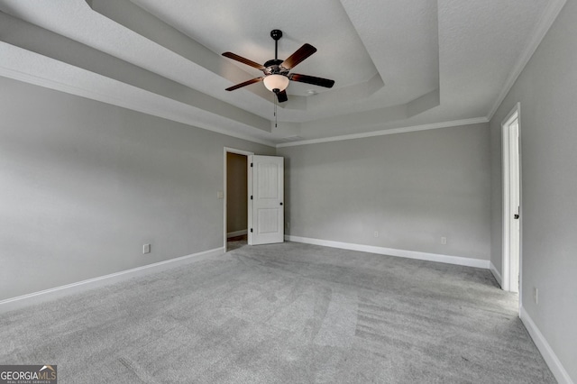unfurnished room featuring baseboards, carpet flooring, a tray ceiling, and ceiling fan