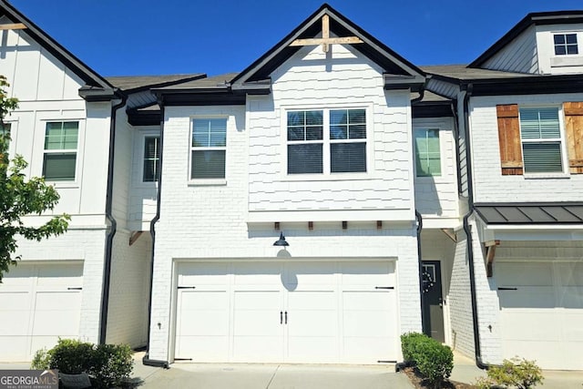 townhome / multi-family property featuring driveway, brick siding, and an attached garage