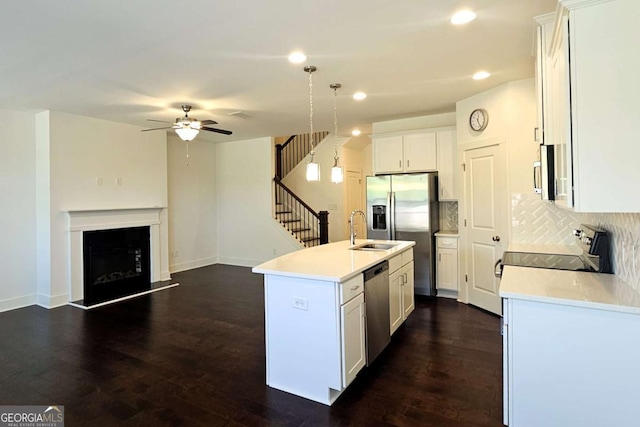 kitchen with a ceiling fan, white cabinets, light countertops, appliances with stainless steel finishes, and decorative backsplash