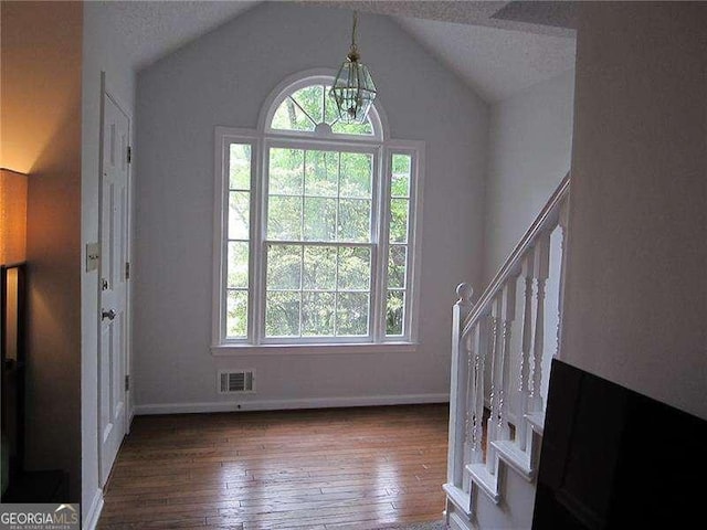 entryway with a healthy amount of sunlight, a chandelier, visible vents, and wood-type flooring