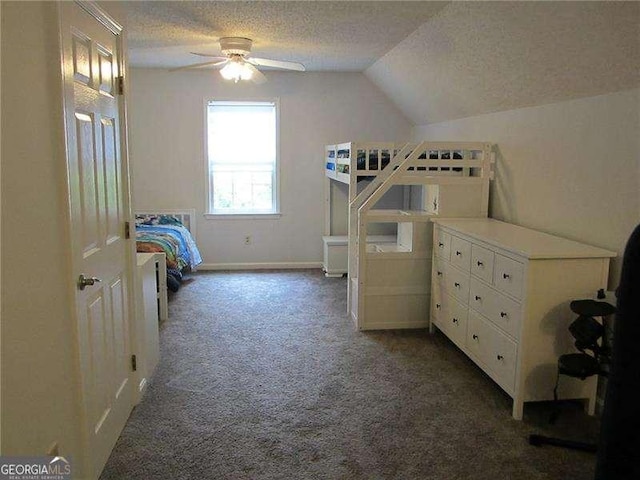 bedroom with baseboards, dark colored carpet, a textured ceiling, and vaulted ceiling