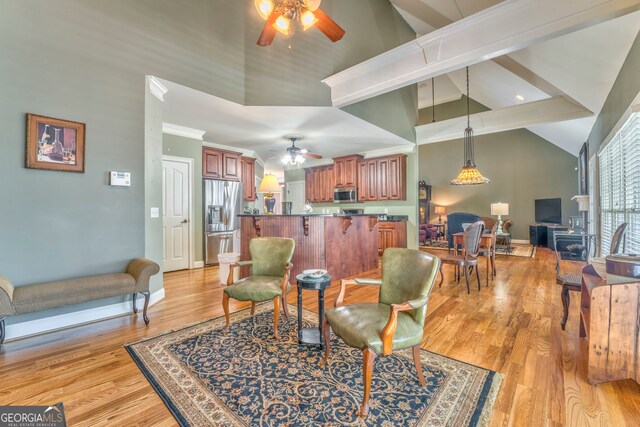 living area with ceiling fan, high vaulted ceiling, light wood-style flooring, and baseboards