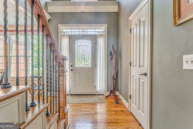foyer with plenty of natural light, light wood-type flooring, and baseboards