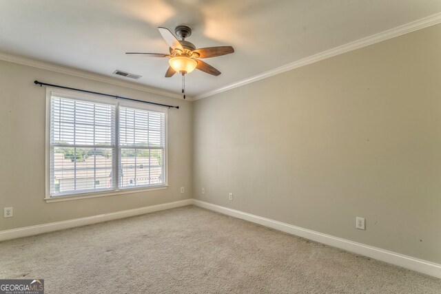 empty room with ornamental molding, ceiling fan, baseboards, and carpet