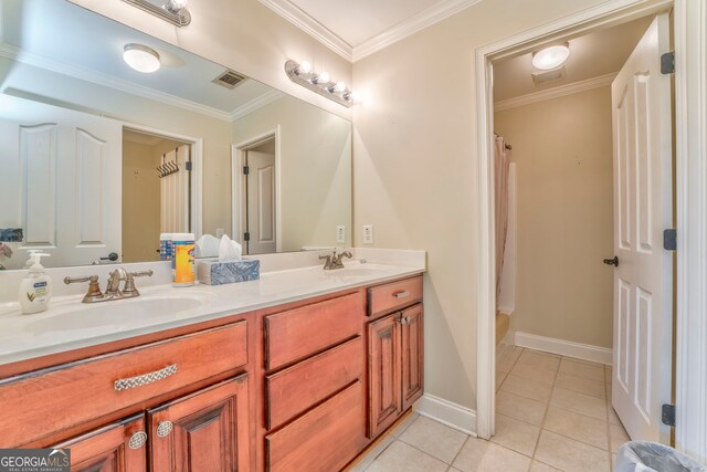 bathroom with tile patterned floors, double vanity, crown molding, and baseboards