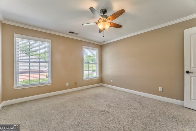 spare room featuring crown molding, baseboards, a ceiling fan, and carpet flooring