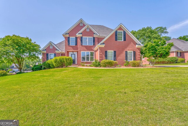 view of front facade featuring brick siding and a front lawn