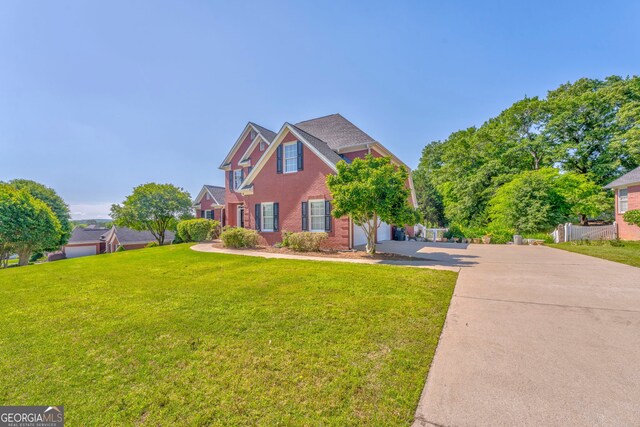 traditional home with driveway, brick siding, and an attached garage