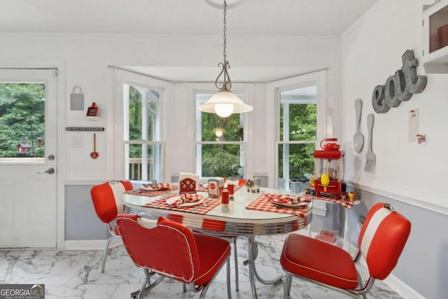 dining area featuring marble finish floor and ornamental molding