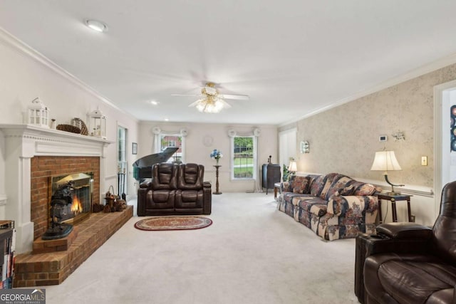 living room featuring crown molding, a fireplace, ceiling fan, and carpet floors