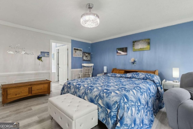 bedroom with crown molding, wood finished floors, a wainscoted wall, and a notable chandelier