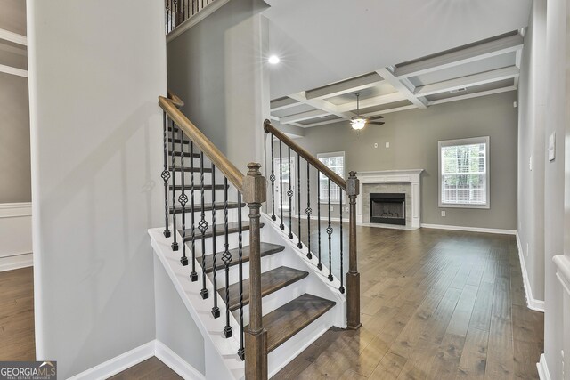 70 Pacific Ave, Sharpsburg, GA 30277 - stairway with coffered ceiling, ceiling fan, wood finished floors, a high end fireplace, and beam ceiling