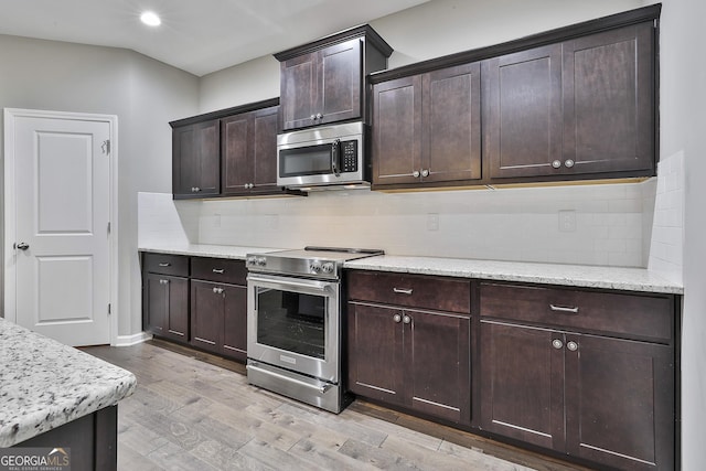 70 Pacific Ave, Sharpsburg, GA 30277 - kitchen featuring appliances with stainless steel finishes, light wood finished floors, dark brown cabinets, decorative backsplash, and recessed lighting