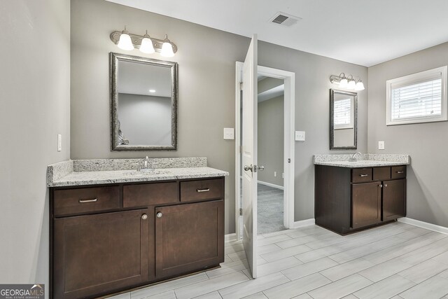 70 Pacific Ave, Sharpsburg, GA 30277 - full bathroom featuring two vanities and baseboards