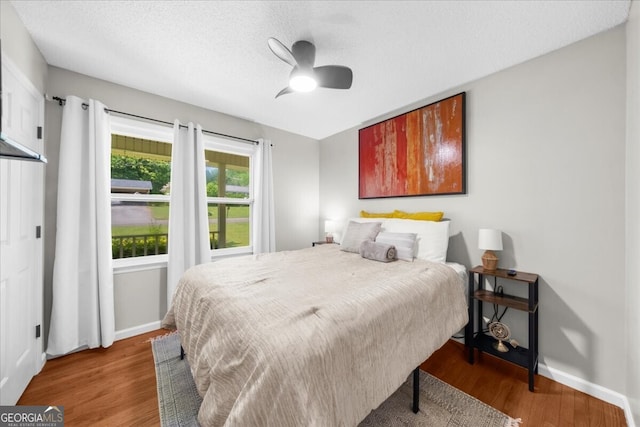 142 Poplar St SW, Calhoun, GA 30701 - bedroom featuring ceiling fan, a textured ceiling, baseboards, and wood finished floors