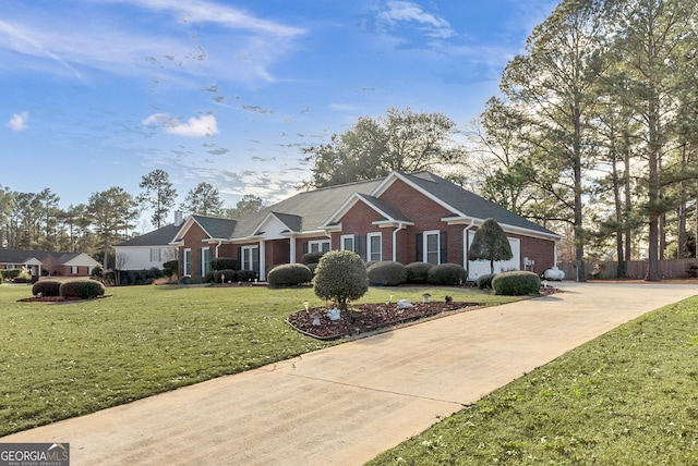 176 Fairethorne Dr, Leesburg, GA 31763 - view of front facade featuring concrete driveway, brick siding, fence, and a front lawn
