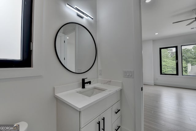 bathroom with a ceiling fan, vanity, recessed lighting, and wood finished floors