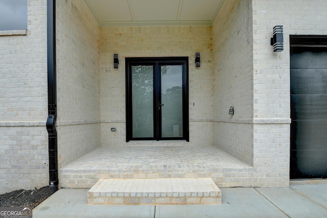 doorway to property featuring french doors and brick siding
