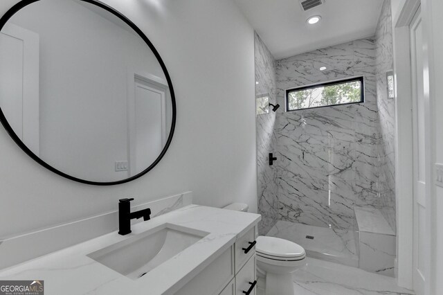 full bathroom featuring recessed lighting, toilet, marble finish floor, vanity, and a marble finish shower