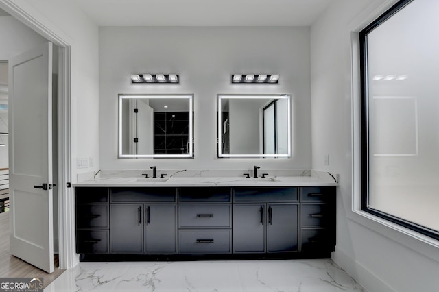 full bathroom featuring a sink, double vanity, baseboards, and marble finish floor