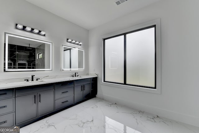 full bath featuring a sink, double vanity, baseboards, and marble finish floor