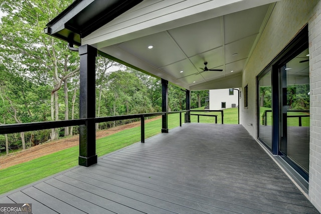 wooden deck with a ceiling fan and a yard