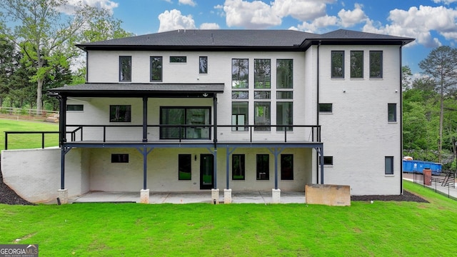 rear view of house featuring a balcony, a yard, and a patio area