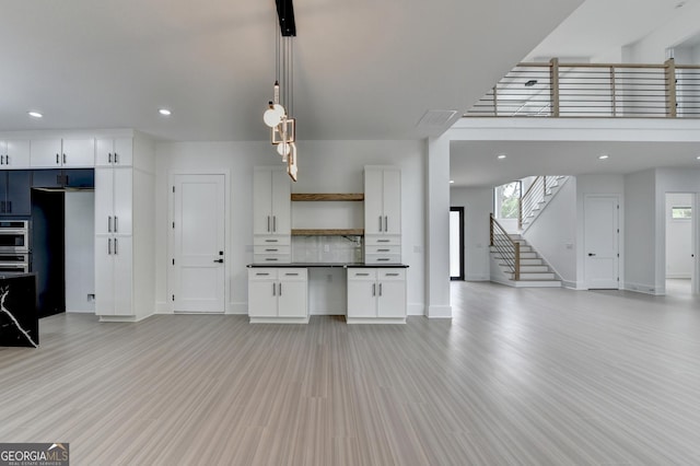 interior space featuring stairway, baseboards, light wood-style flooring, and recessed lighting