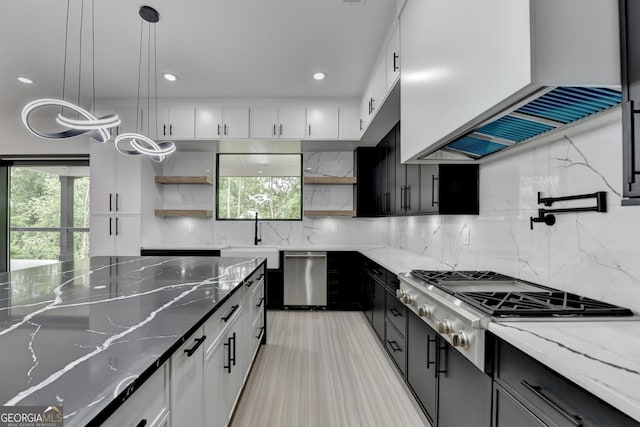 kitchen with a sink, custom range hood, open shelves, backsplash, and appliances with stainless steel finishes