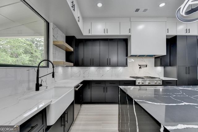 kitchen with a sink, open shelves, white cabinetry, backsplash, and appliances with stainless steel finishes