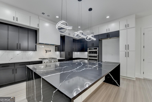 kitchen featuring dark stone counters, light wood-type flooring, visible vents, tasteful backsplash, and recessed lighting