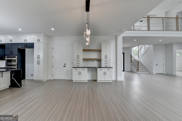 kitchen with open shelves, dark countertops, baseboards, and open floor plan