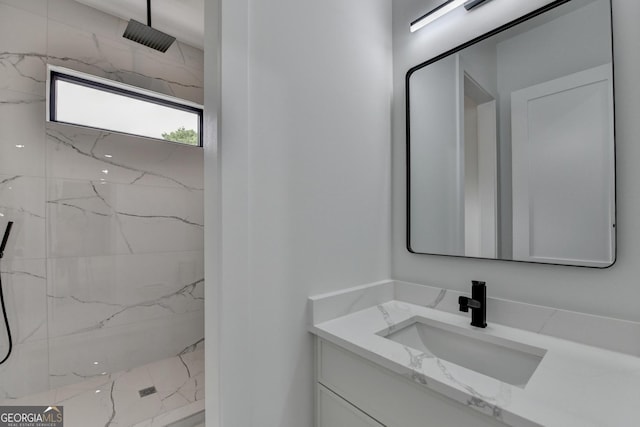 bathroom with a marble finish shower and vanity