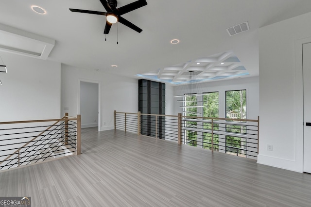 spare room featuring coffered ceiling, baseboards, visible vents, and recessed lighting