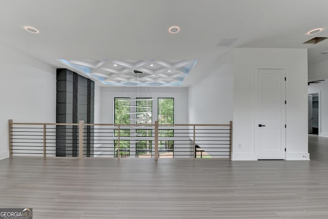unfurnished living room featuring beamed ceiling, recessed lighting, coffered ceiling, and wood finished floors