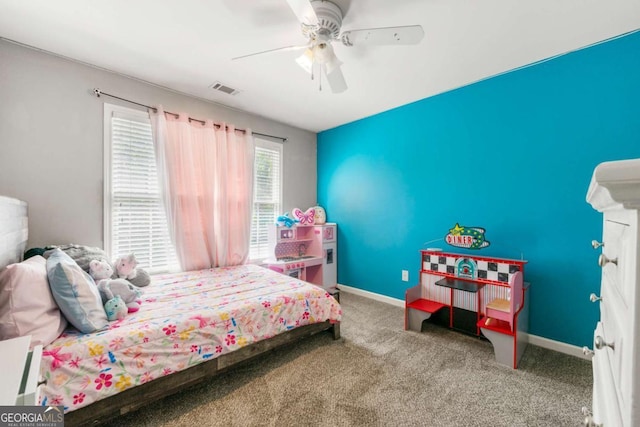 carpeted bedroom with visible vents, baseboards, and a ceiling fan