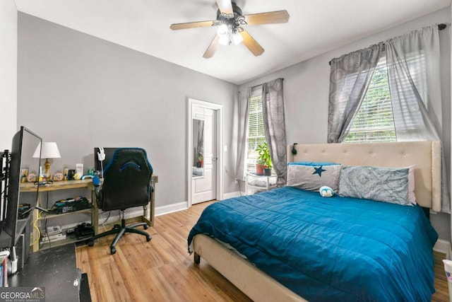 bedroom with ceiling fan, baseboards, and wood finished floors