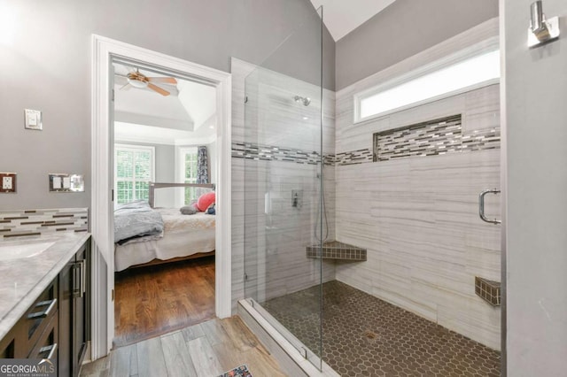 ensuite bathroom with a ceiling fan, ensuite bathroom, wood finished floors, and a shower stall