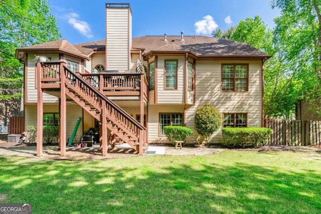 back of house featuring a chimney, a yard, fence, stairway, and a wooden deck