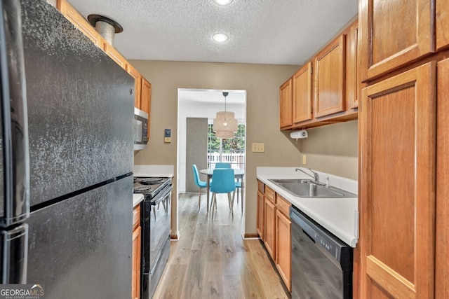 1750 Clairmont Rd Unit 32, Decatur, GA 30033 - kitchen featuring black appliances, light wood-style floors, a textured ceiling, light countertops, and brown cabinets
