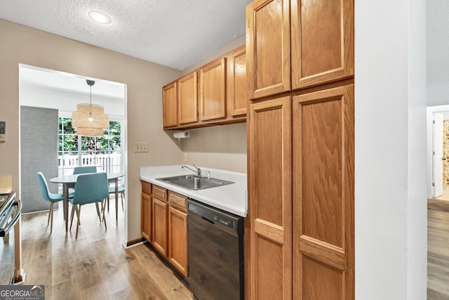 1750 Clairmont Rd Unit 32, Decatur, GA 30033 - kitchen featuring dishwasher, light wood finished floors, a textured ceiling, light countertops, and pendant lighting