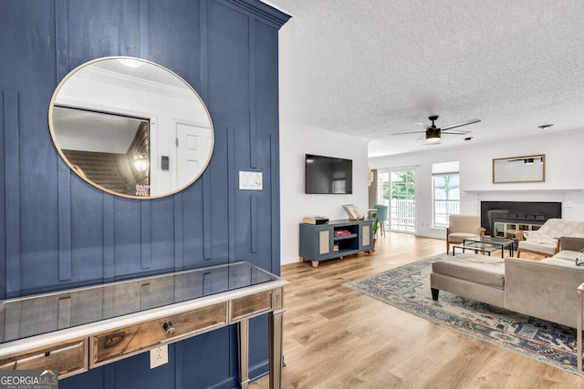 1750 Clairmont Rd Unit 32, Decatur, GA 30033 - living area with ceiling fan, a textured ceiling, light wood-type flooring, and a glass covered fireplace