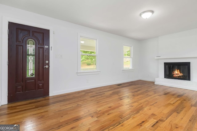 3781 Cherokee Trl, Suwanee, GA 30024 - unfurnished living room featuring wood finished floors and a brick fireplace