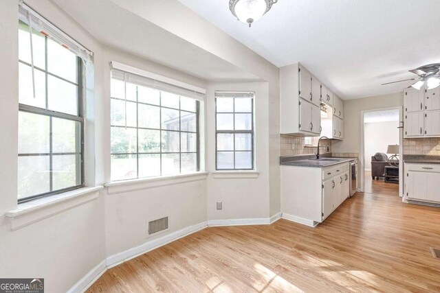 522 Knollwood Dr, Stockbridge, GA 30281 - kitchen featuring baseboards, visible vents, white cabinetry, decorative backsplash, and light wood-style floors