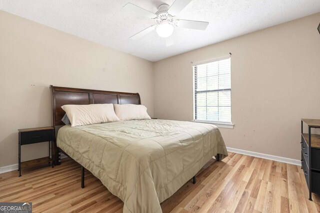 522 Knollwood Dr, Stockbridge, GA 30281 - bedroom with light wood-style flooring, a textured ceiling, baseboards, and a ceiling fan