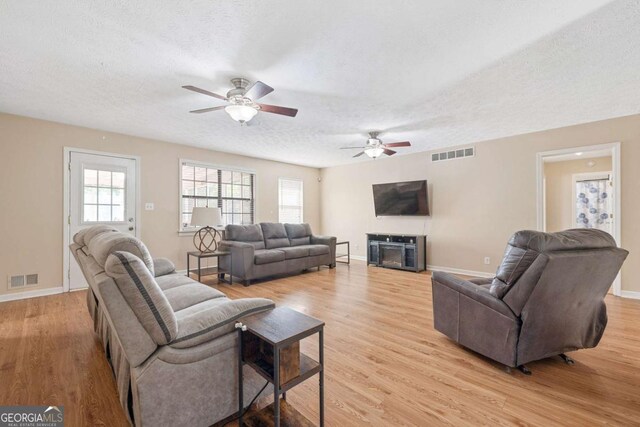 522 Knollwood Dr, Stockbridge, GA 30281 - living room featuring ceiling fan, a textured ceiling, light wood finished floors, and visible vents